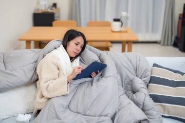 Kadın battaniyenin altında kendini hasta hissediyor.