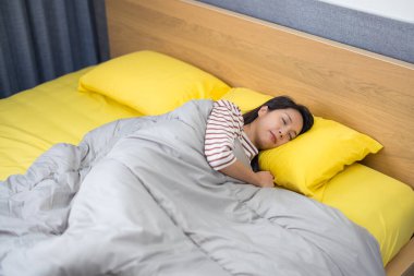 Yatakta yalnız uyuyan kadın.