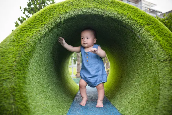 Küçük bebek dışarıda parkta oynuyor.