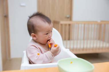 Bebek Evde Yüksek Sandalyede Havuç Tadını Çıkartıyor