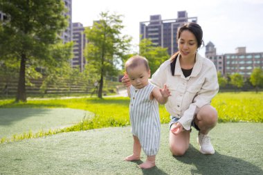 Anne ve küçük çocuk parkta eğleniyor.
