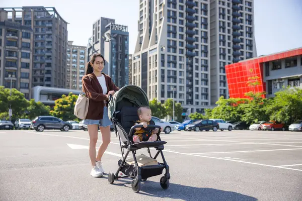 Annem bebek arabasıyla dışarıda yürüyor.