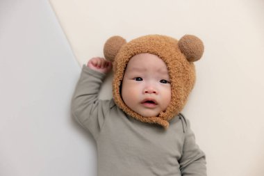 Sevimli ayı şapkalı küçük bebek ve yatakta yatıyor.