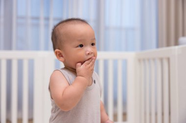 Bebek evde ağzına dokunuyor.