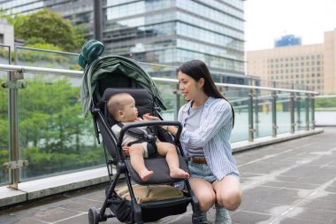 Anne, bebek arabasındaki küçük oğluna bak.