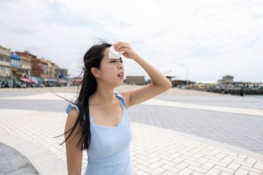 Kadın terini temizliyor.