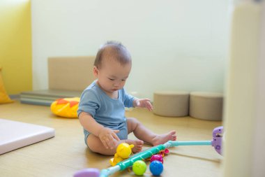 Küçük bebek paspaslı oyun evinde sürünüyor.