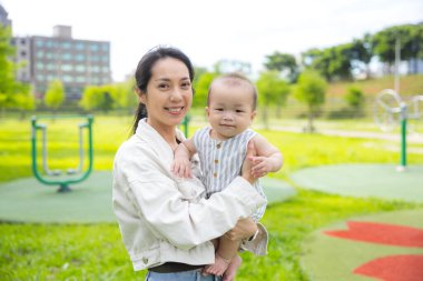 Küçük bebek annesiyle parka gidiyor.