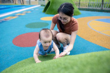 Küçük bebek dışarıda annesiyle oynuyor.