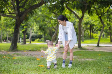 Anne oğlunun elini tut ve çimenlerde yürü.
