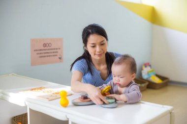 Bebek, annesini seven bir oyun eviyle kaliteli vakit geçirmekten hoşlanıyor.