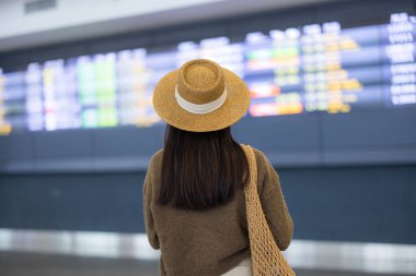 Arka plan kadını uçuş çizelgesini izliyor