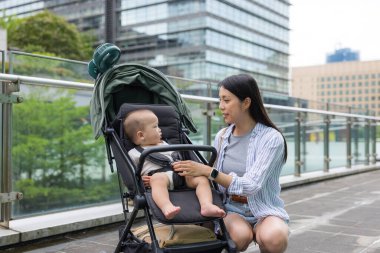 Anne, şehirde bebek arabasındaki bebeğine bak.