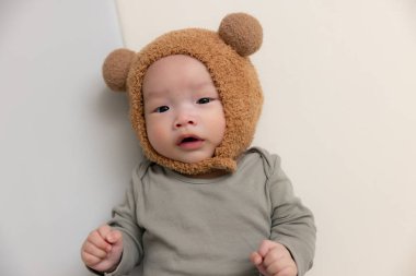 Sevimli ayı şapkalı küçük bebek ve yatakta yatıyor.