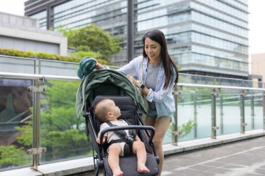 Anne, bebek arabasındaki küçük oğluna bak.