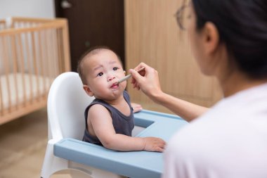 Bebeği beslerken kaşıkla yemek püresi