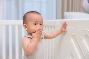 Bebek evde ağzına dokunuyor.