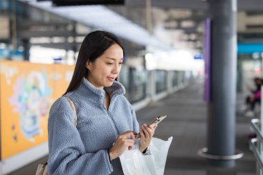 Tayvan metro istasyonunda telefon kullanan bir kadın.