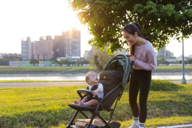 Anne küçük oğluyla bebek arabasında dışarı çıktı.