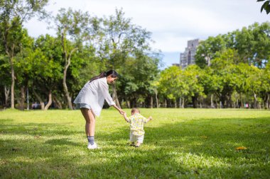 Anne oğlunun elini tut ve çimenlerde yürü.