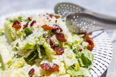 Beyaz tabakta servis edilen taze sezar salatası.