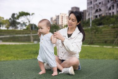 Anne ve oğul parkta birlikte yürüyorlar.