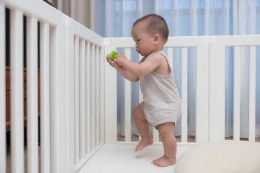 Oyun parkında oyuncaklarla oynayan şirin bebek.