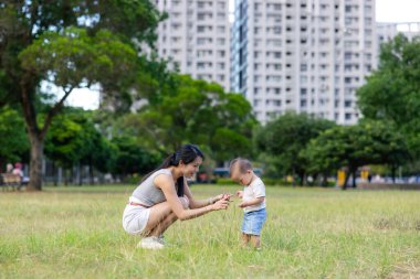 Mother play with her baby son at park