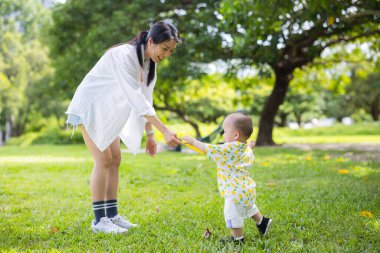 Anne oğluyla parkta oynuyor.