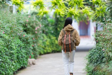 Bahçede yürüyüş yapan bir kadının arka görüntüsü