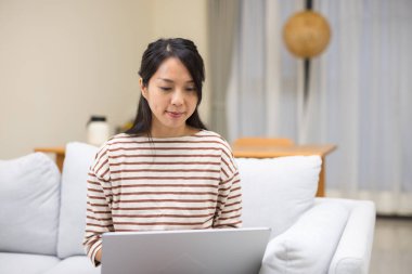 evde dizüstü bilgisayar üzerinde çalışan kadın