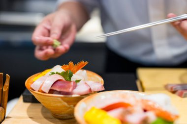 Yetenekli şef geleneksel Japon saşimi kasesi yapıyor.