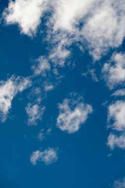 Soft, cotton-like clouds gracefully float across a deep blue sky, creating a stunning contrast and a peaceful, airy canvas that invokes a sense of calm and expansiveness. clipart