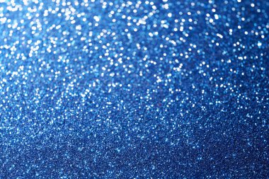 Yumuşak bokeh ışıklarıyla parıldayan mavi parıltının yakın çekimi, neşeli ve rüya gibi soyut bir arkaplan oluşturur.