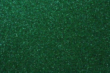 Işıldayan yüzeyi olan canlı yeşil simli kağıdın yakın çekimi, el sanatları, tatiller ve şenlik tasarım temaları için mükemmel..