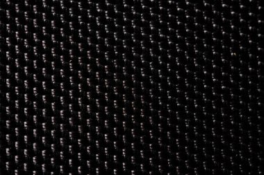 Sıkı örülmüş siyah karbon fiberin makro görüntüsü parlak ve yüksek güçlü bir desen gösteriyor.