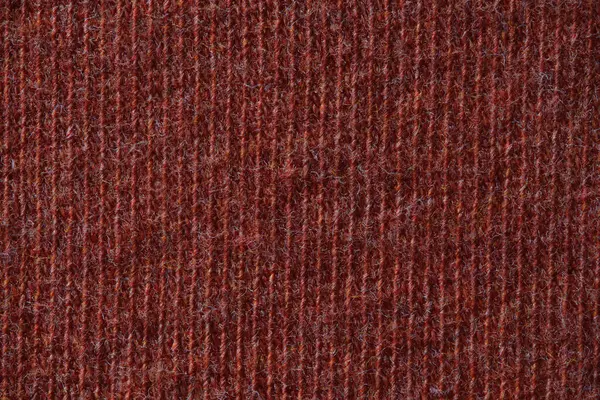 Görünür tüylü iplikleri ve sıkı dikişleri olan sıcak kırmızı yün kumaşın makro görüntüsü.