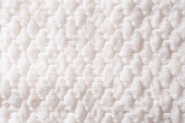 Macro texture of soft, fluffy white cotton with a repeating, padded surface pattern.