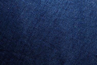 Macro shot showing detailed texture of classic blue denim fabric with visible weave pattern.