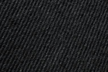 Detailed macro image of black wool knit fabric showing its soft, textured yarn pattern, ideal for fashion or textile backgrounds.
