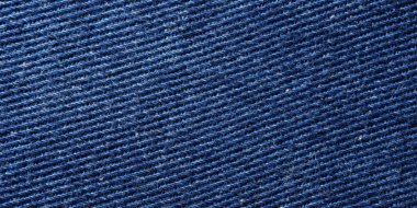 Macro shot of dark blue denim fabric showing twill weave texture and detailed yarn structure.