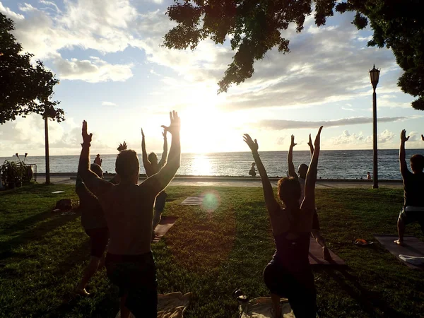 怀基基 2014年11月15日 夏威夷火奴鲁鲁 人们在怀基基海滩为慈善团体做 勇士一袋日落瑜伽 船上有水 夕阳西下 — 图库照片