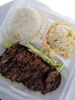 Izgara biftek, bir kepçe beyaz pilav ve köpüklü makarna salatası Hawaii usulü yerel yemek tabağı.. 