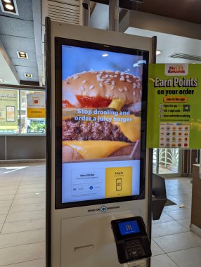 Waikiki- January 30, 2022: McDonalds Touch Screen Kiosk with Ads for Hamburger in Waikiki, Hawaii.  McDonald's primarily sells hamburgers, cheeseburgers, chicken, french fries, breakfast items, soft drinks, milkshakes, desserts.