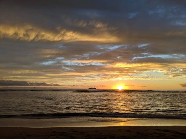 Altın saat sihri: Waikiki sahilinin sakin sularında güneşin batışını izlemek, Oahu, Hawaii