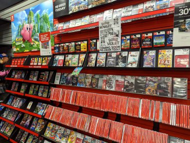 Honolulu - 16 Mart 2022: GameStop mağazası çeşitli Nintendo Switch oyunları sergiliyor. Popüler oyunlarda Kirby ve Unutulmuş Topraklar, Pokmon ve diğerleri yer alır. Mağazada çeşitli aksesuarlar ve oyunlarla ilgili diğer ürünler de bulunmaktadır.. 