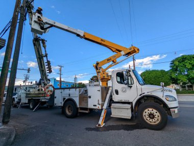 Honolulu - 1 Mart 2022: Kendini işine adamış işçiler, Kuzey King Caddesi 'nde hayati önem taşıyan bir elektrik direğini onarmak için yeteneklerini kullanıyorlar..