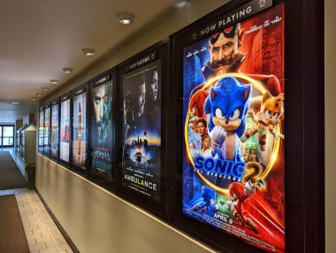 Honolulu - April 11, 2022: Row of movie posters including Sonic the Hedgehog 2, Ambulance, Morbius and others outerside of movie theater in Kahala Mall. clipart