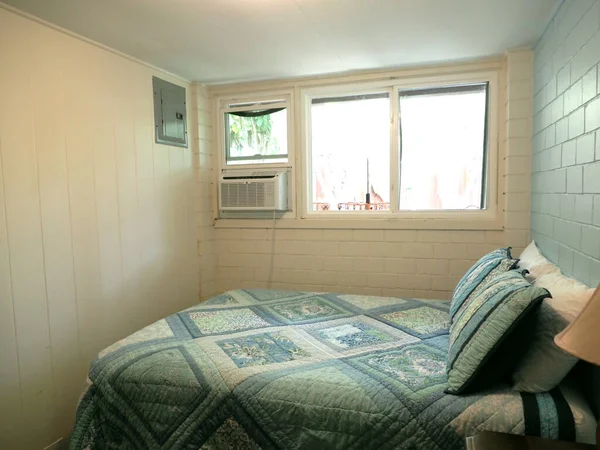 舒适而迷人的楼下卧室 有一张超大的床 一个木制床头柜和一盏灯 卧室有窗户 空调和一个能提供充足存储空间的衣柜 对于想要隐私的客人或家庭成员来说 卧室是完美的 — 图库照片