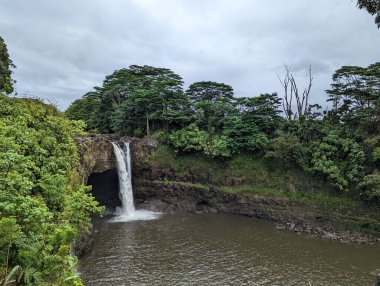 Wailuku Nehri 'nde geniş bir şelale Hilo, Hawaii' deki bir lav mağarası üzerinde çağlar.. 